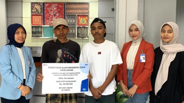 Penyerahan manfaat klaim Asuransi Mikro Kecelakaan, Kesehatan, dan Meninggal Dunia (AMKKM) kepada keluarga nasabah yang ditinggalkan (Dok. Istimewa)